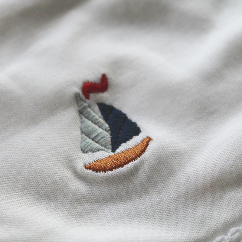 white cotton bib with sailboat